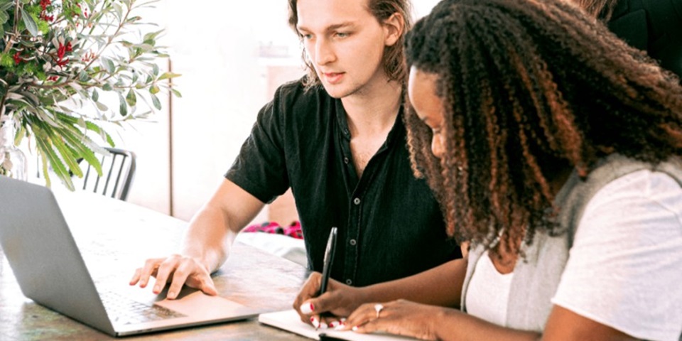 Group of students collaborating toghether at laptop