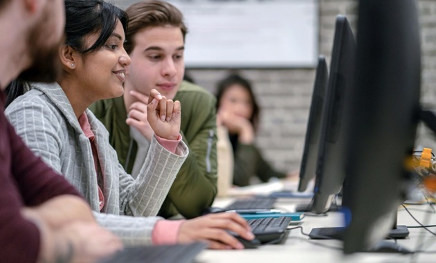 Group of students sitting at desktop computers