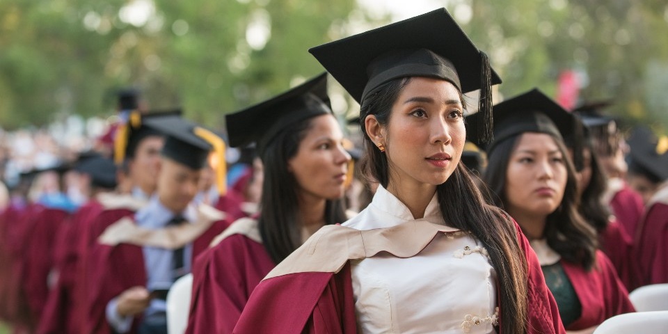 Murdoch graduates sitting outside during their graduation ceremony