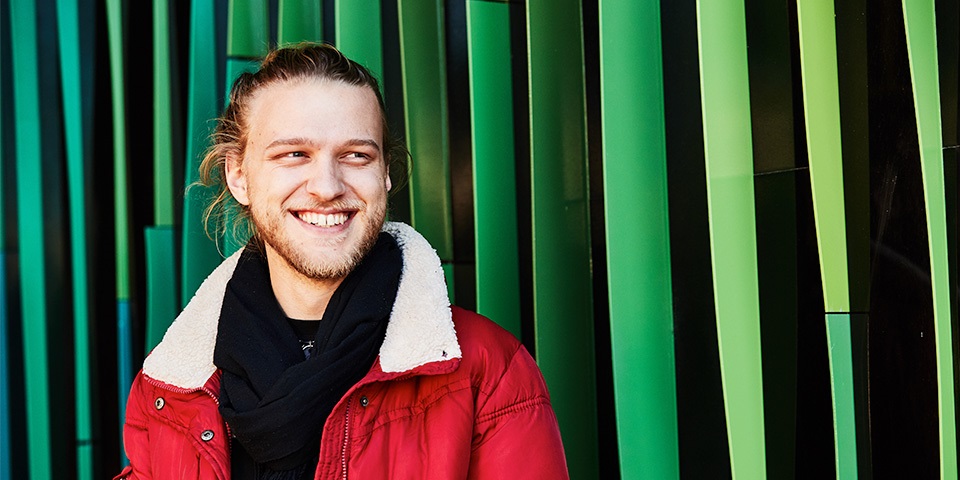 Young bearded student smiling off camera