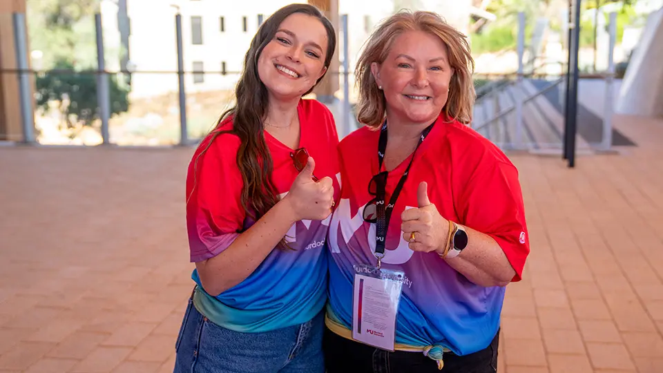 2 staff members doing thumbs up