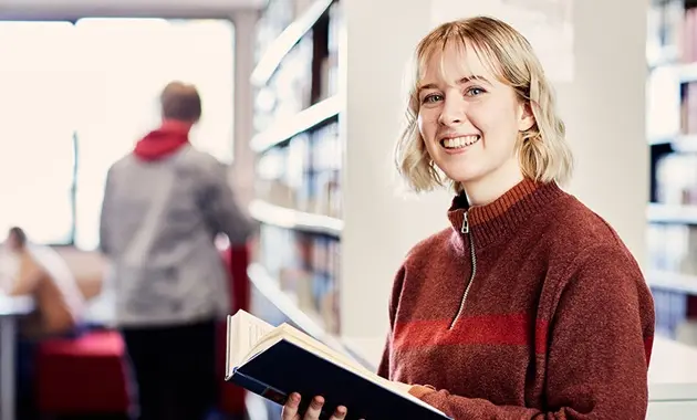 Student in library reading book