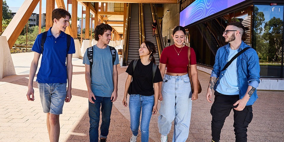 5 students walking in front of Boola Katitjin building