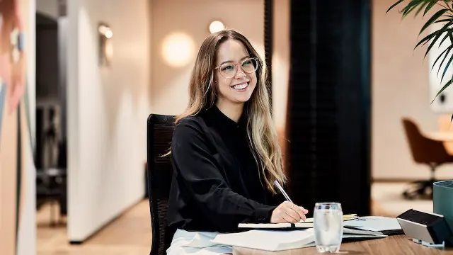Student writing at desk