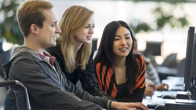 students looking at computer talking