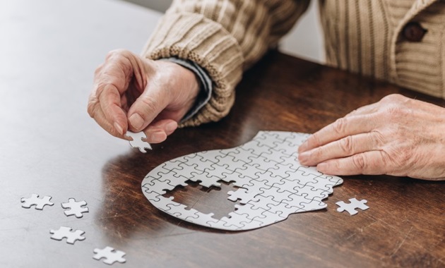 A man doing a puzzle of a brain.