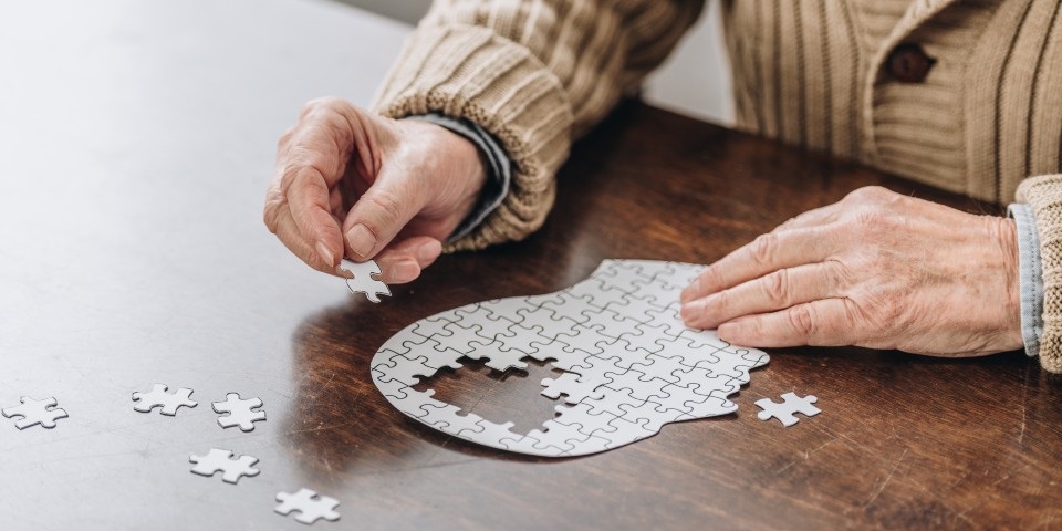A man doing a puzzle of a brain.