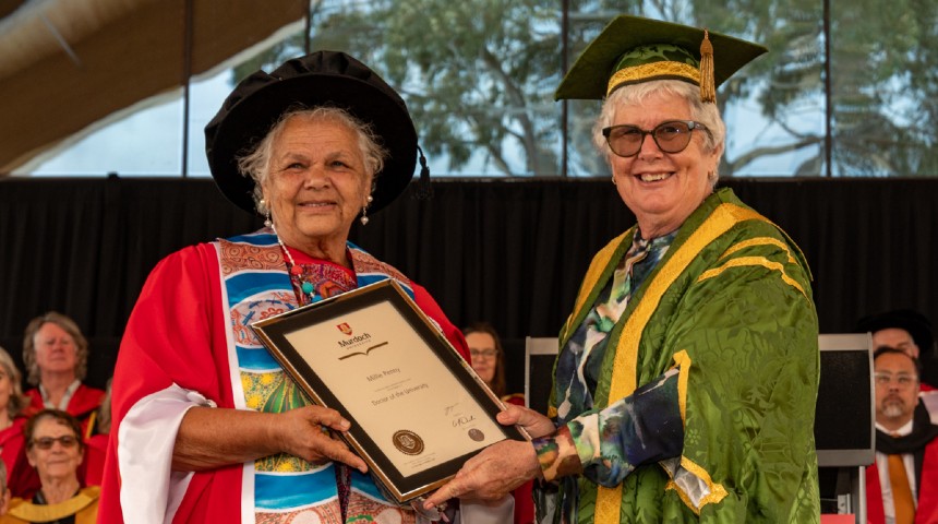 Aunty Millie Penny, Honorary Doctor of the University 2025, at the Murdoch University graduation ceremony with Chancellor Gail McGowan who is handing her the doctor certificate.