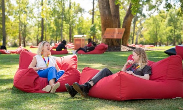 Murdoch alumnus and staff member chatting on bush court