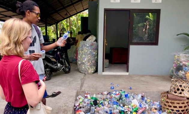 people looking at empty plastic bottles for recycling