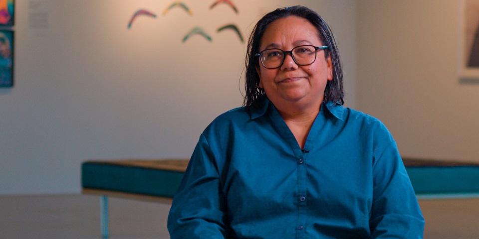 Voices of reconciliation: Murdoch community shares what it means to them Woman smiling at camera in art gallery