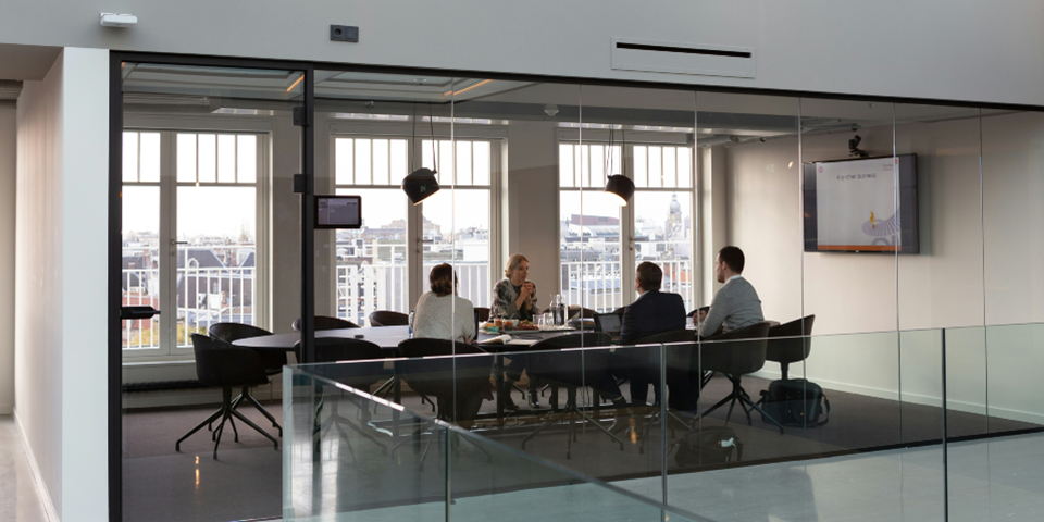 Four people sitting around a table in a  boardroom