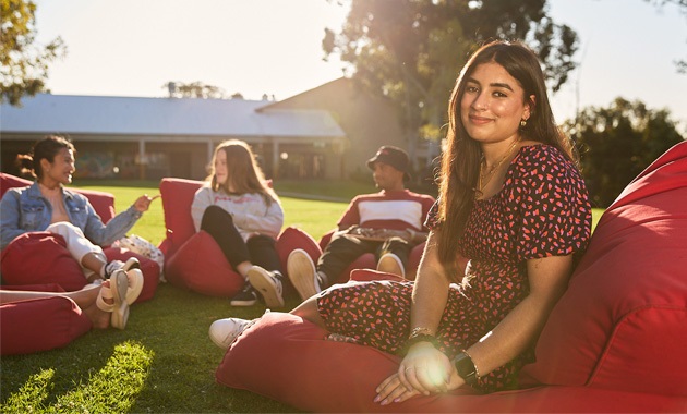 Female student sitting on bean bag outside