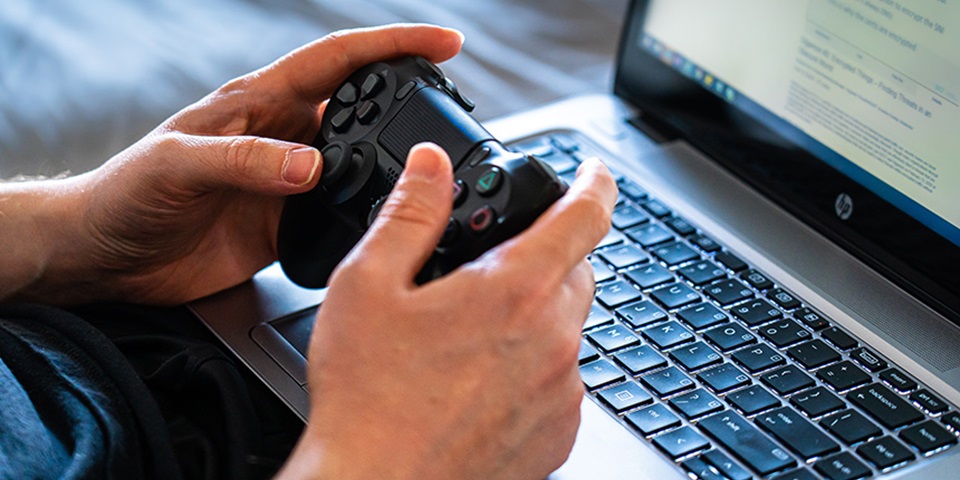 Child using video game handset with computer