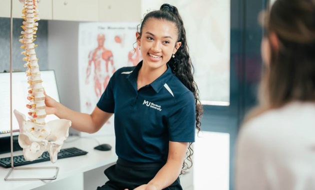 Murdoch Chiropractic student showing a spine to a patient