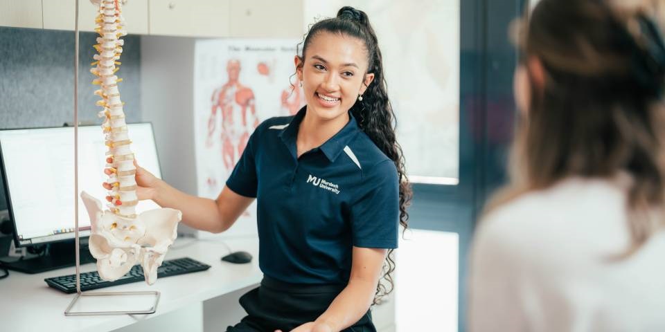 Murdoch Chiropractic student showing a spine to a patient