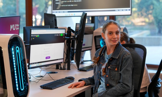 A student learning to code at a desk.