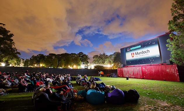 People sitting on beanbags at an outside cinema