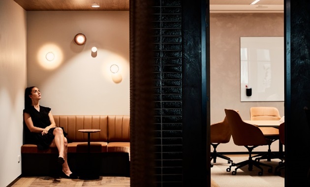Girl sitting in office building looking up at light wondering