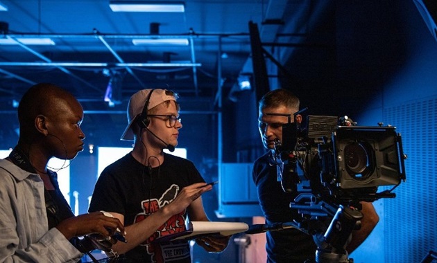 Students look through video camera in a studio