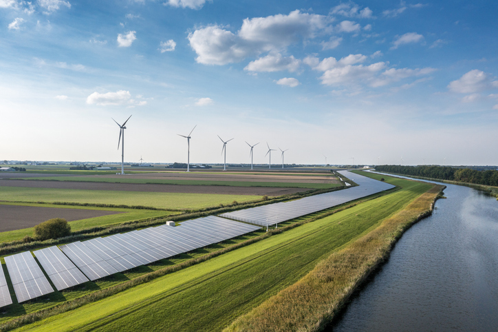 Solar panels and wind turbines in a lush green field in the country. Solar panels and wind turbines in a lush green field in the country.