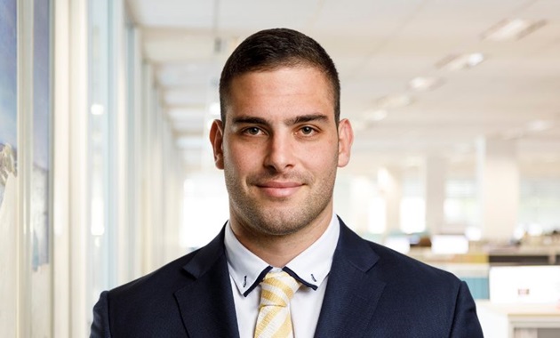 Student in suit smiles to camera