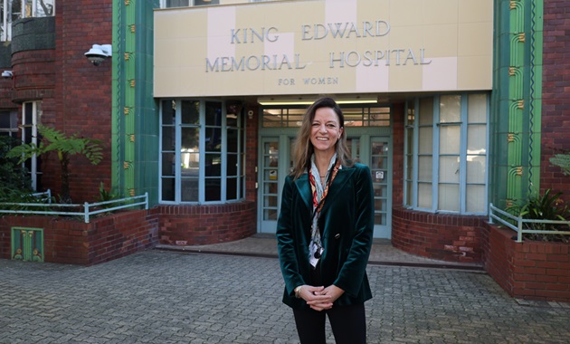 Kelli MacMillan standing in front of King Edward Memorial Hospital.