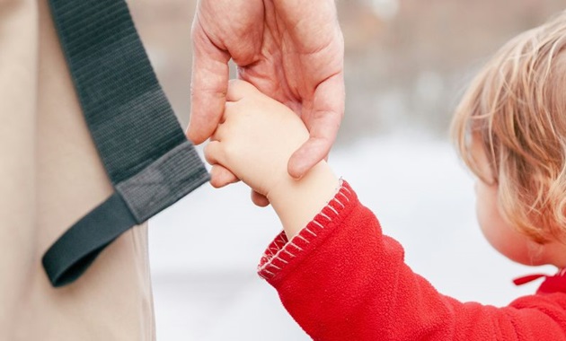 A parent and child holding hands. Photo by Laura Ohlman on Unsplash.