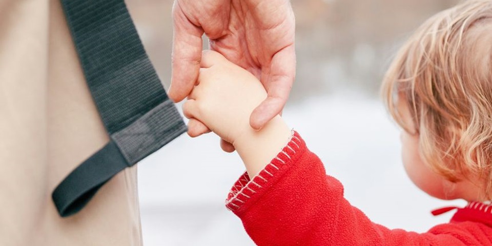 A parent and child holding hands. Photo by Laura Ohlman on Unsplash.