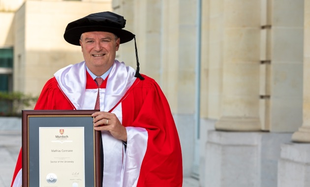 Dr Mathias Cormann holding his Honourary Doctorate