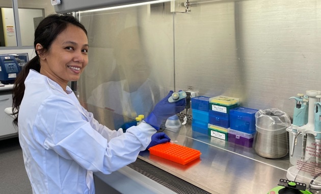 Dr May Aung-Htut smiles at camera while working in genomics laboratory