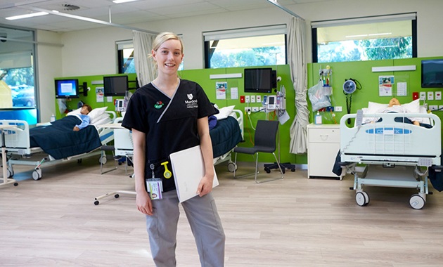 A Murdoch  University nursing student stands in the simulated ward