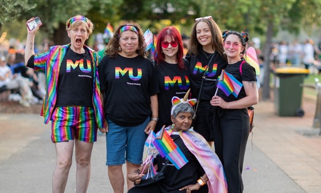Murdoch University staff at the Perth PrideFEST, standing together smiling, wearing Pride at MU shirts.