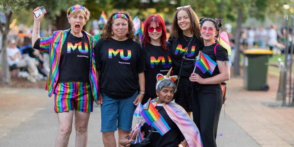 Murdoch University staff at the Perth PrideFEST, standing together smiling, wearing Pride at MU shirts.