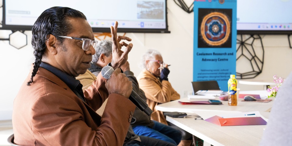 Man speaking into a microphone at the water roundtable event