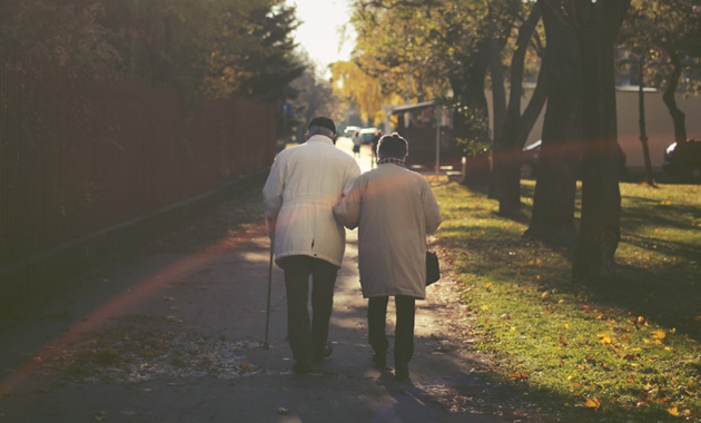 An elderly couple walking down the steet