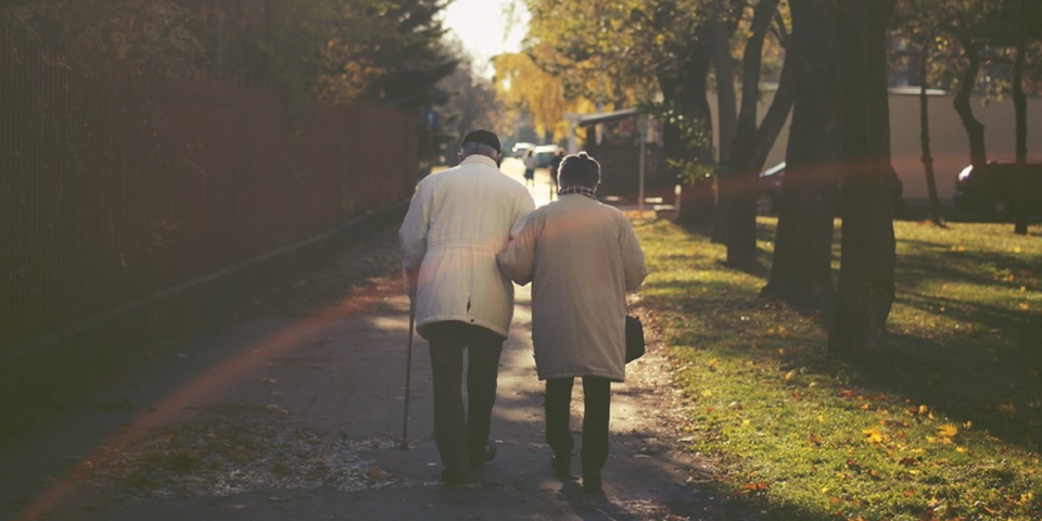 An elderly couple walking down the steet