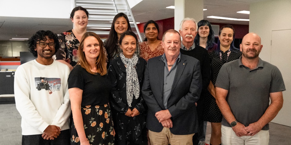 11 scientists standing on stairs looking at camera