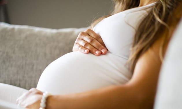 Woman with her hands over her pregnant belly