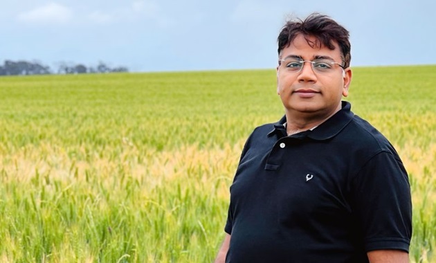 Professor Rajeev Varshney stands in field.