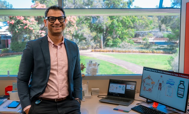 Man standing and smiling at camera in an office at Murdoch University