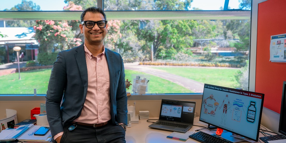 Man standing and smiling at camera in an office at Murdoch University