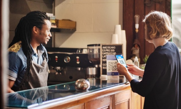 woman scanning qr code in cafe