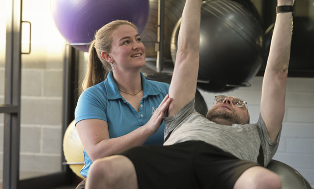 Rahni, a Murdoch University graduate, working with a client on adapted exercise