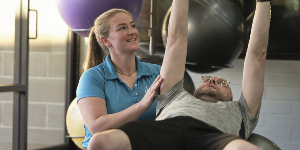 Rahni, a Murdoch University graduate, working with a client on adapted exercise
