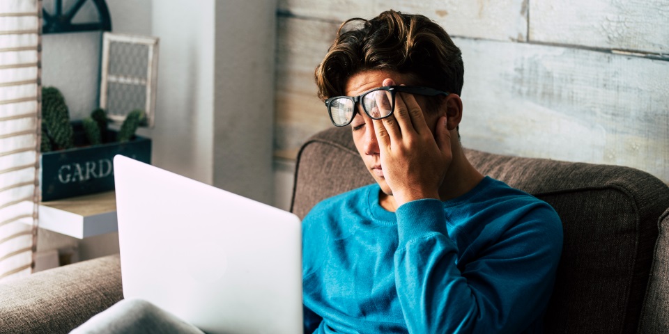 Sleepy young adult with laptop