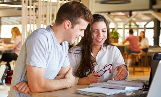 2 students in student hub on campus