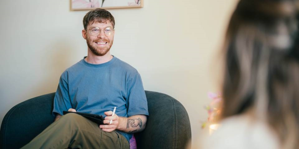 Psychology setting with a psychologist and patient chatting on couches