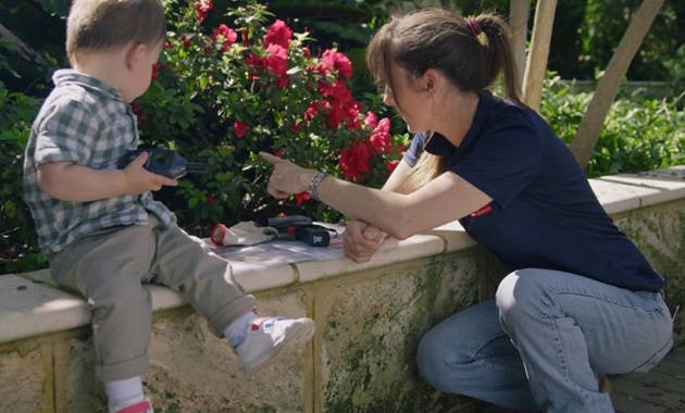 A scientist showing a young boy plants on the Murdoch University campus