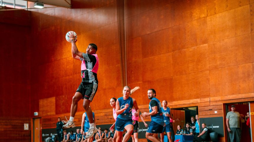Mid game at the netball Grand Final, a Kulbardi student is in the air holding the ball.